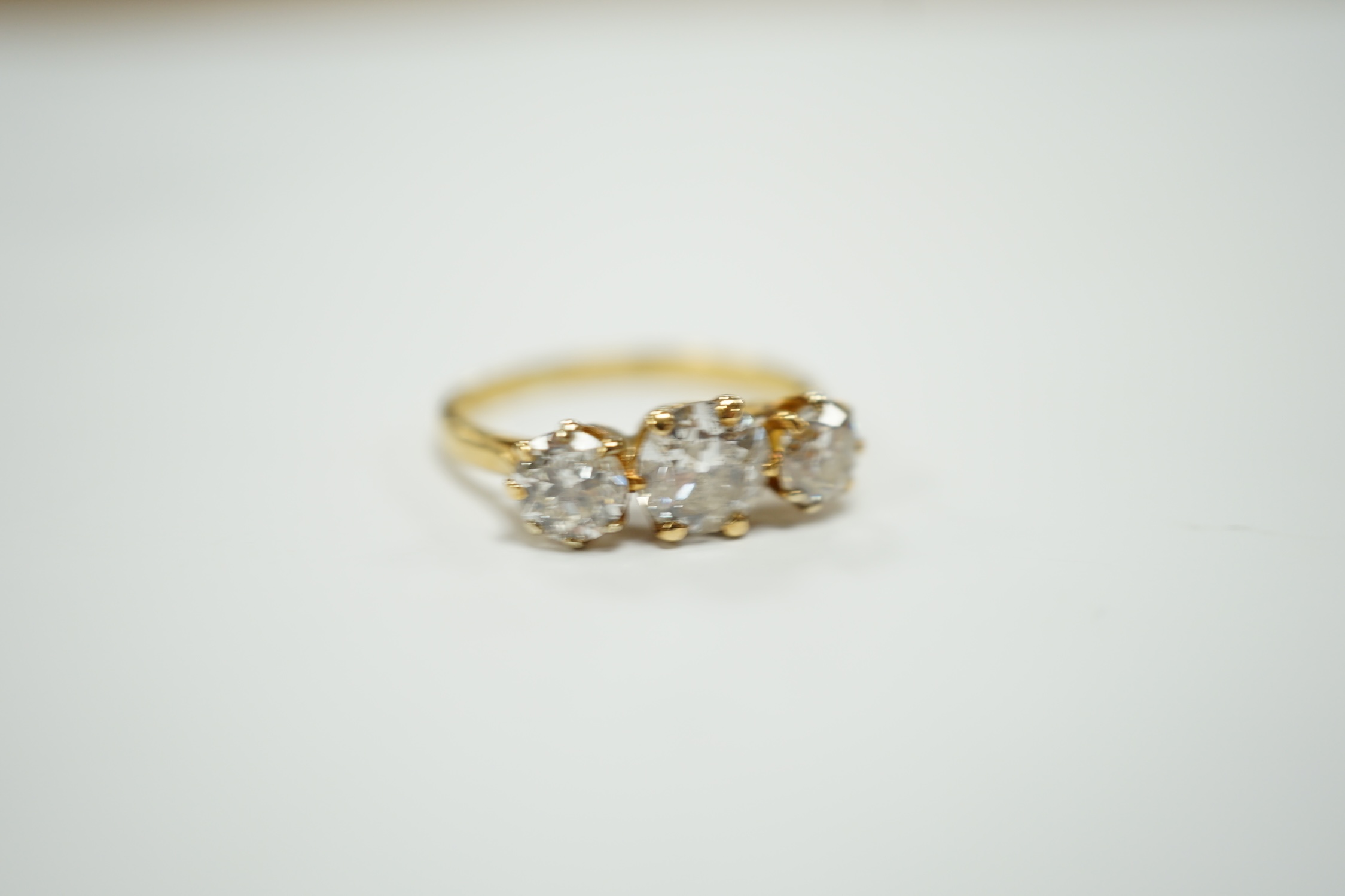 A George V 18ct gold and three stone diamond set ring, the central stone weighing approx. 0.60ct, size L, gross weight 2.5 grams.